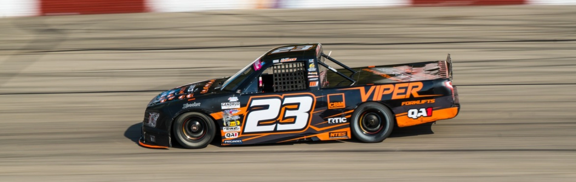 No. 23 black and orange Viper Forklifts short-track race truck competing in the Midwest Truck Series
