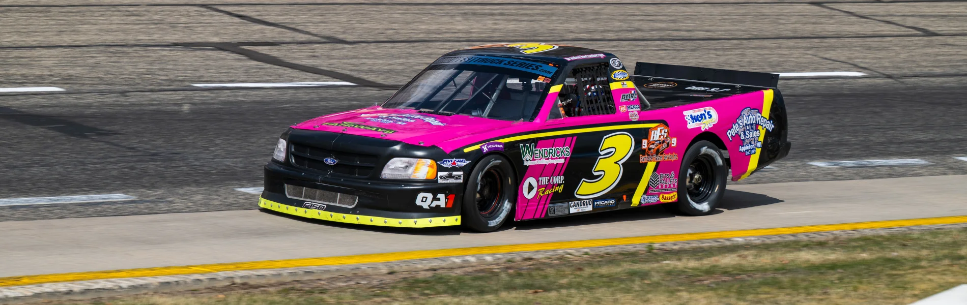 No. 23 black and orange Viper Forklifts-sponsored race truck in motion on a short-track oval